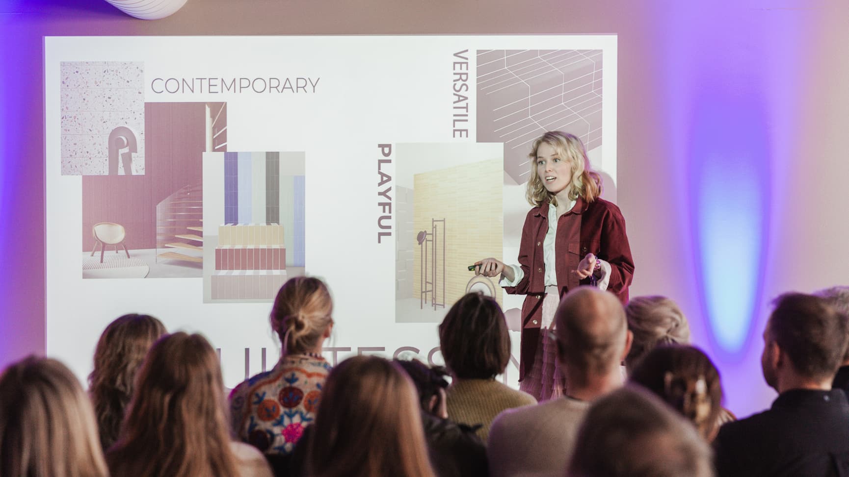 Foredragsholder som står på scenen og forklarer noe